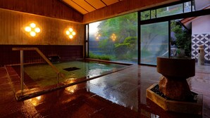 Un área de piscina interior moderna con paredes de madera y ventanas amplias.