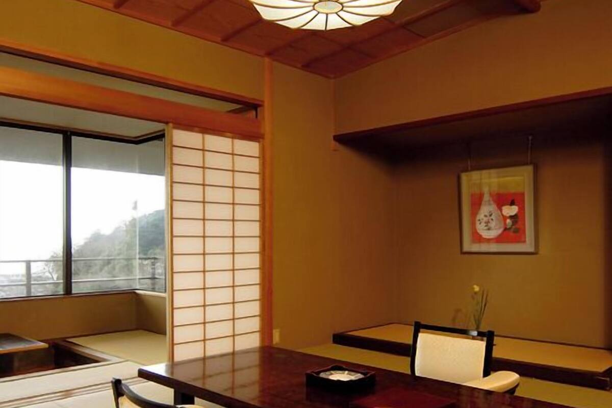 Ein traditioneller japanischer Raum mit Tatami-Böden, einem niedrigen Tisch und einem Shoji-Bildschirm.