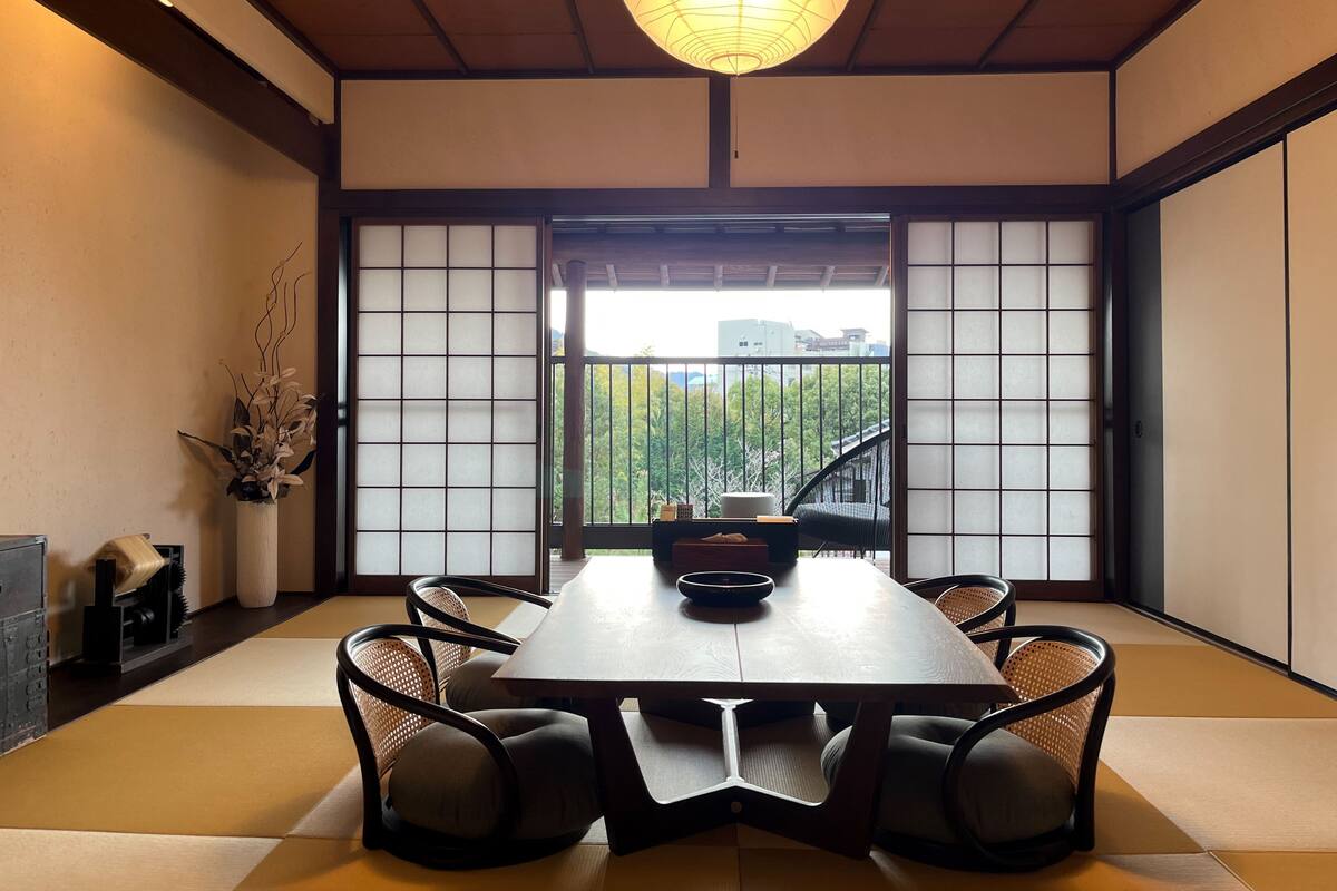 Ein traditioneller japanischer Raum mit Tatami-Böden, einem niedrigen Tisch und Shoji-Schirmwänden.