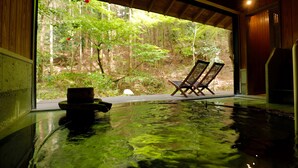 Una piscina interior con vistas a un bosque a través de un amplio ventanal.