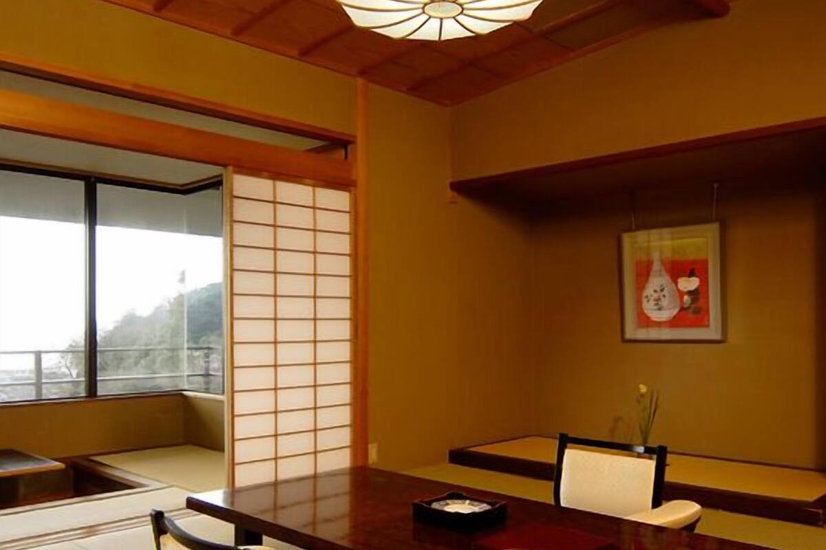 A traditional Japanese room with tatami flooring, a low wooden table, and a shoji screen.