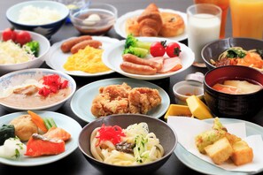 A variety of dishes including noodles, fried items, and vegetables on a table. - Aishinkan (Morioka)