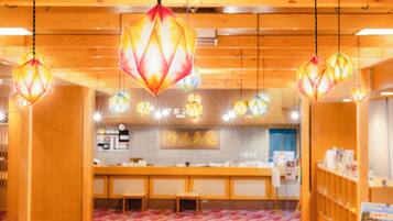 Een restaurant interieur met hangende zeshoekige lampen, houten meubels en een betegelde vloer.
