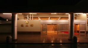A building entrance with a sign, a red carpet, and a glass door. - Aishinkan (Morioka)