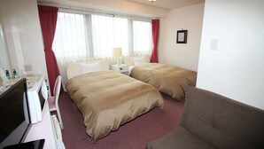 A hotel room with two beds, a desk with a computer, a chair, and a couch. - Mihara City Hotel (Mihara)