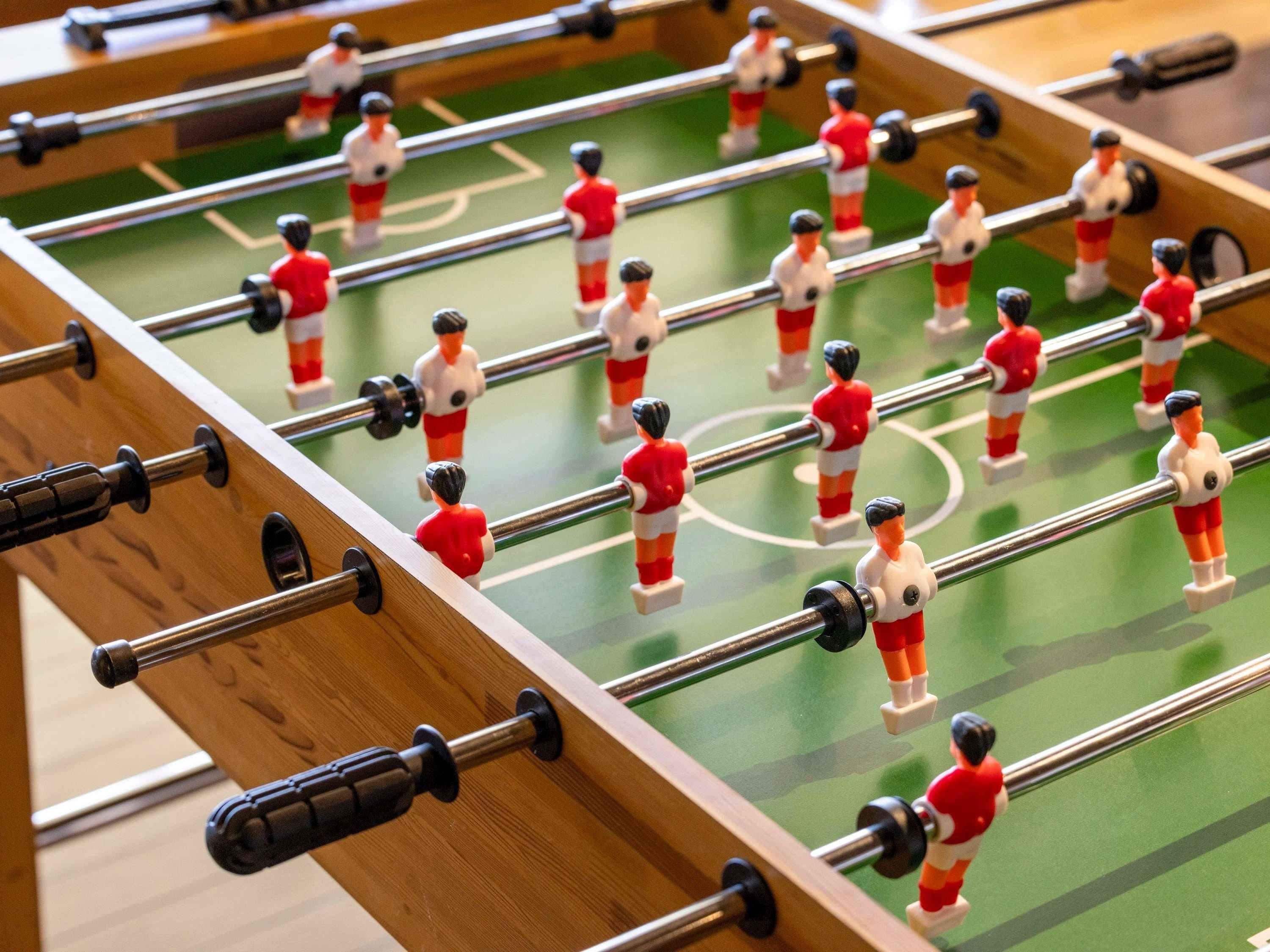 A close-up of a foosball table with miniature figures and rods.