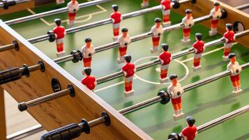 A close-up of a foosball table with miniature figures and rods.