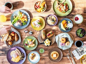 A variety of food items on a wooden table, including sandwiches, fruits, and pastries. - Mercure Kochi Tosa Resort & Spa (Geisei)