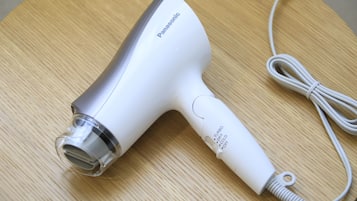 Um secador de cabelo Panasonic sobre uma superfície de madeira.