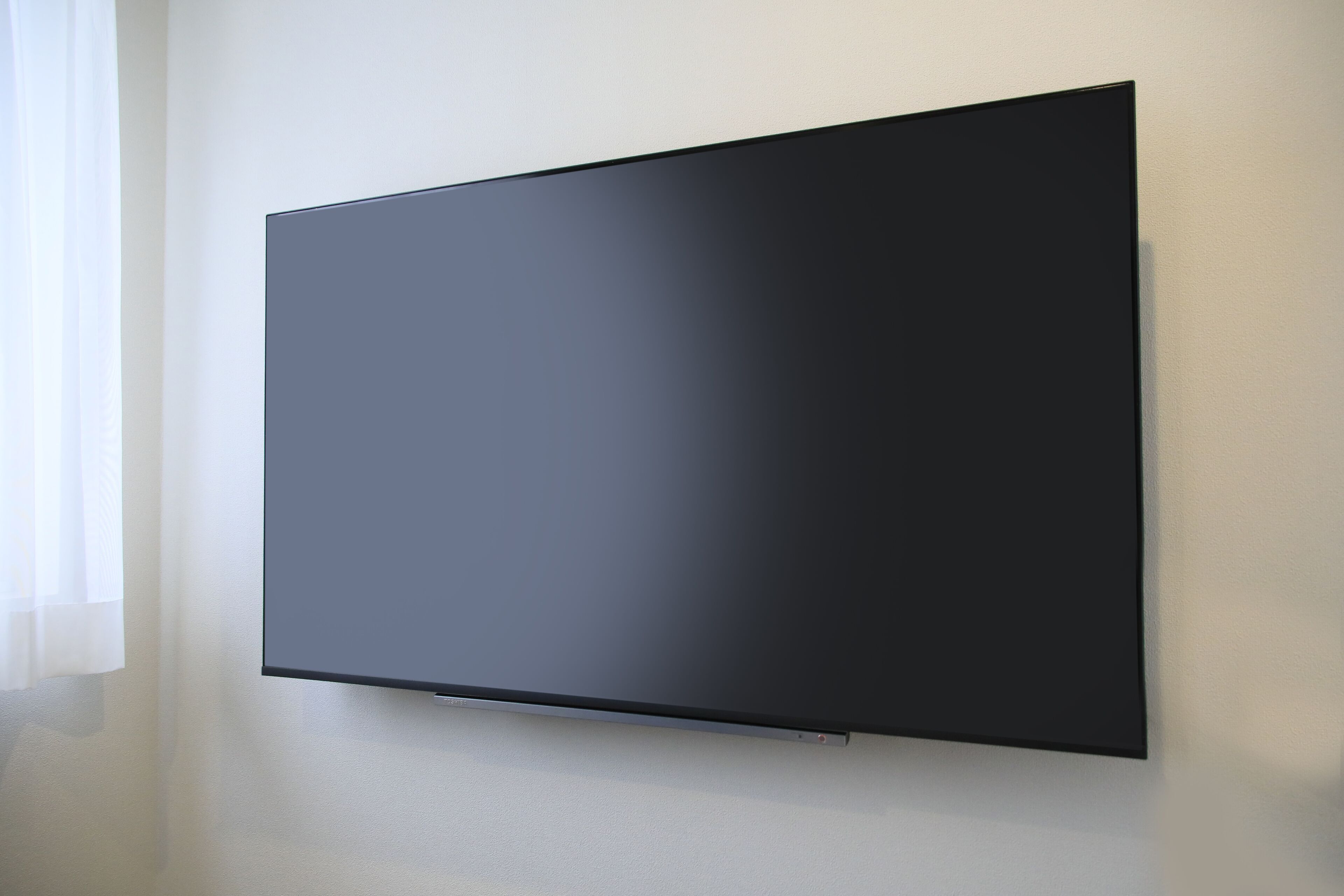 Ein Flachbildfernseher an einer schlichten Wand.