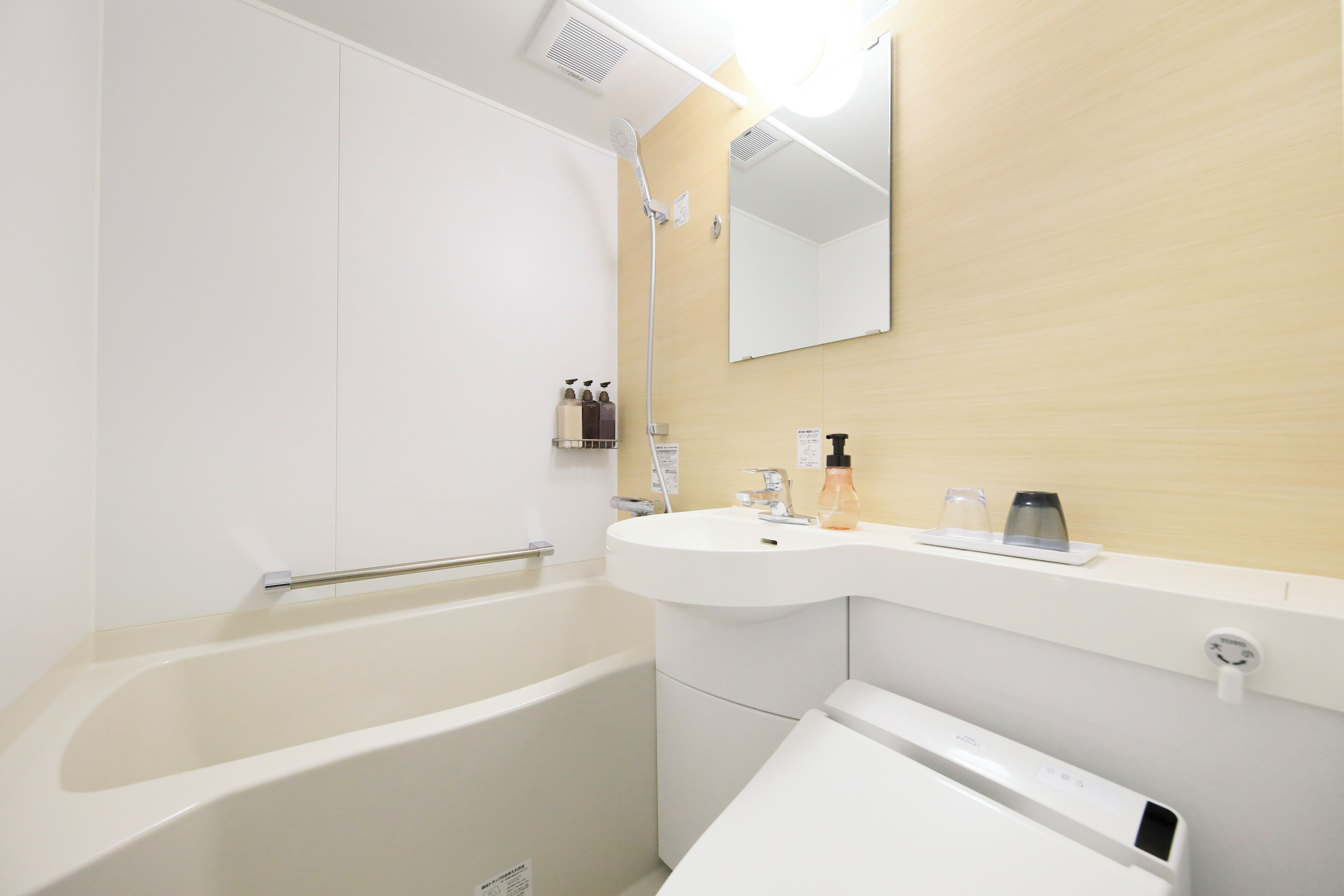 Un baño moderno con bañera, lavamanos y espejo.