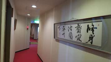 Un pasillo con una obra de caligrafía enmarcada en la pared.