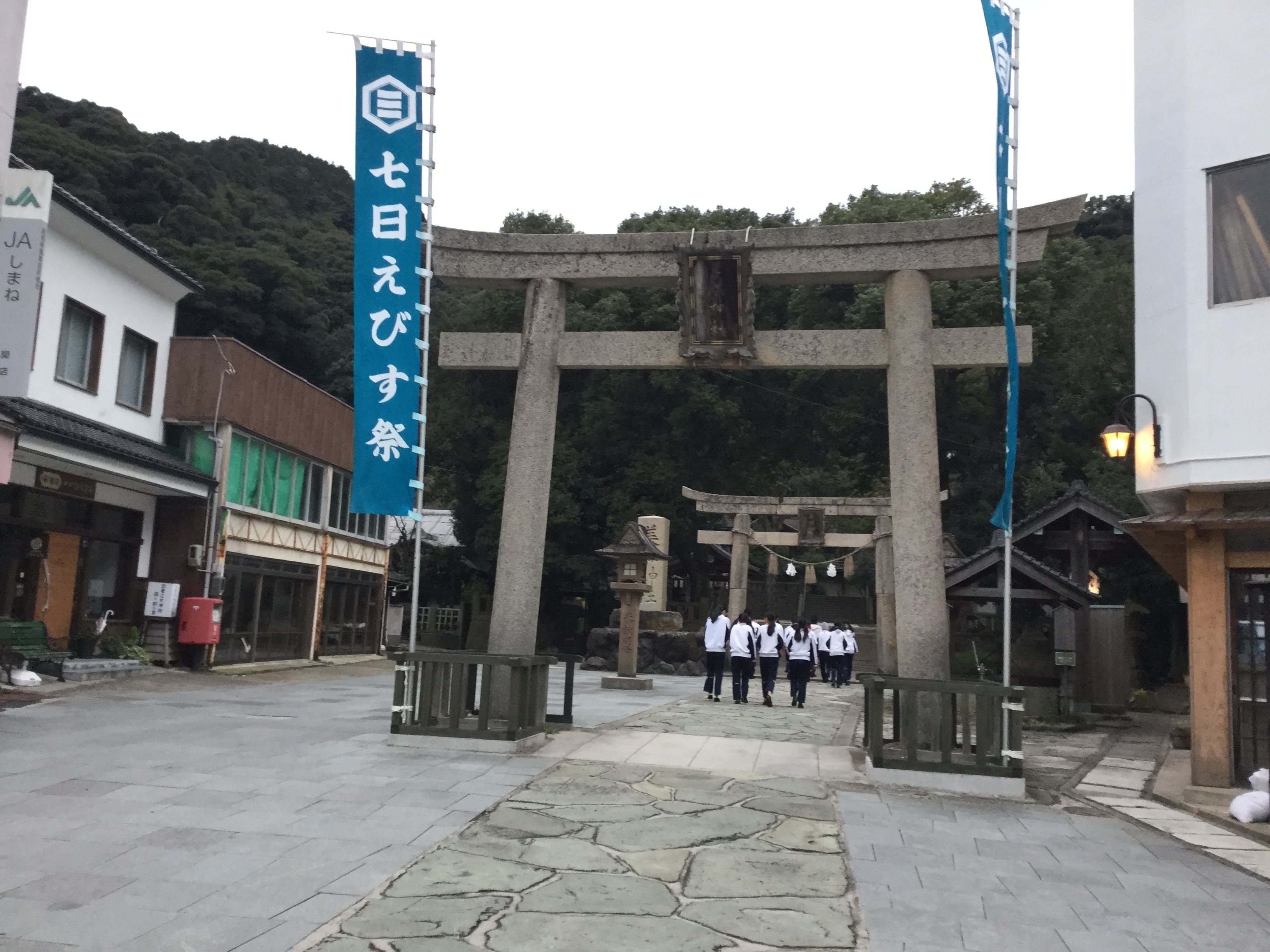 Un portail torii japonais traditionnel, typique des sanctuaires, se dresse à l’entrée, avec un chemin de pierre menant jusqu’à lui.