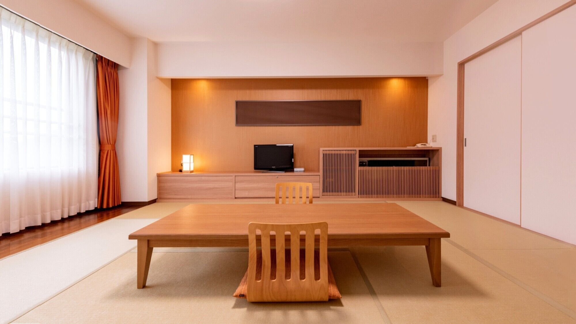 A modern room with a wooden dining table, chairs, a TV, and a cabinet.
