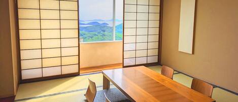 Una habitación japonesa tradicional con suelo de tatami, una mesa de madera y paneles shoji.