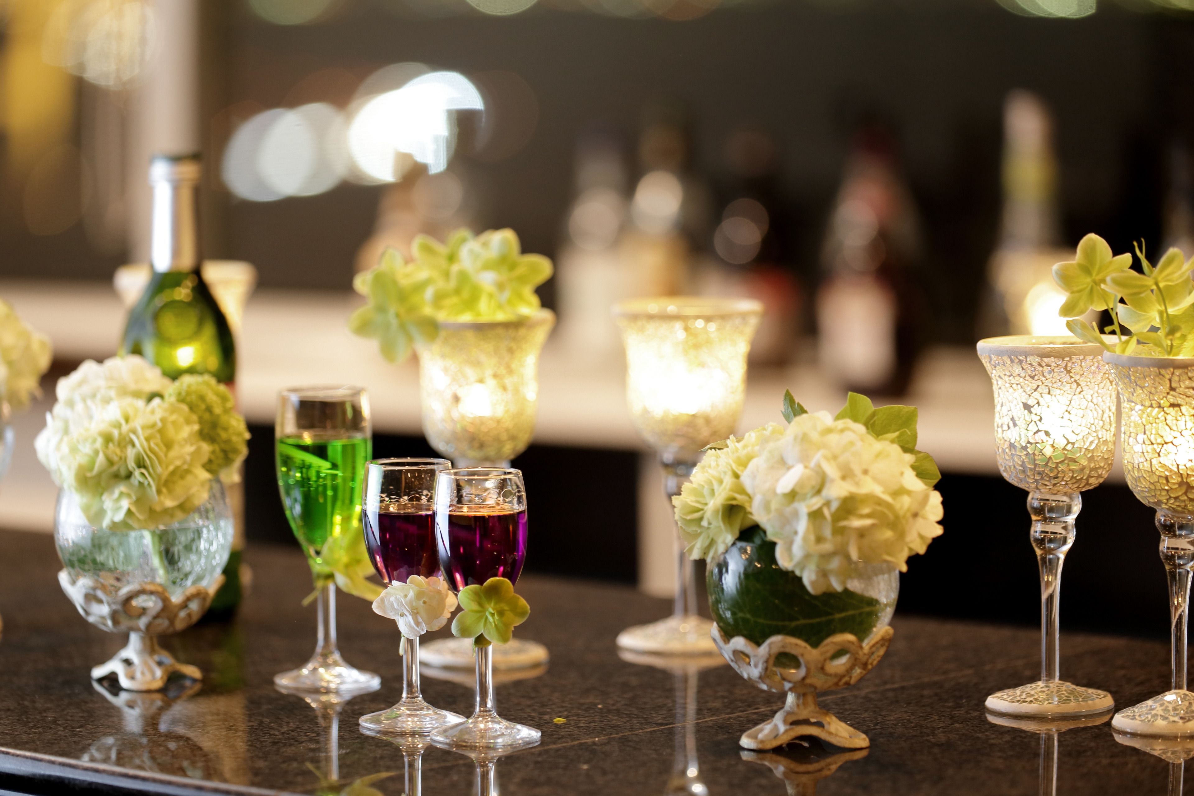 Una zona de bar con diferentes vasos y adornos florales.