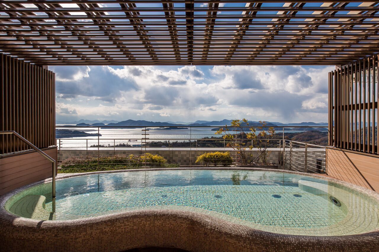 Uma banheira de hidromassagem com vista para um lago e montanhas.