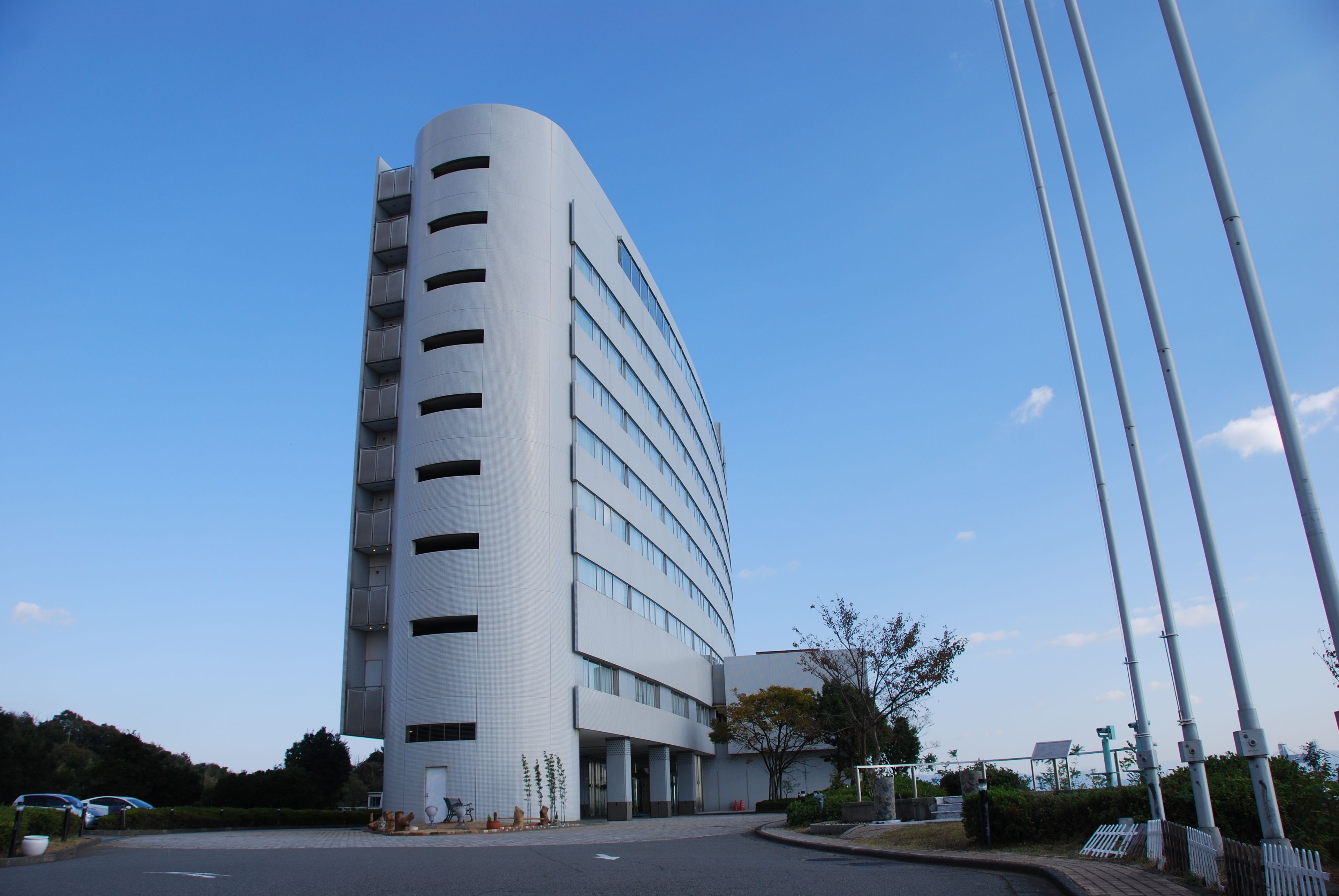 A modern, curved hotel building with multiple floors and large windows.