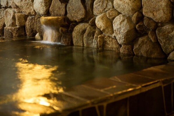A stone wall with a water feature in the foreground. - New Grande Mimatsu (Takamatsu)