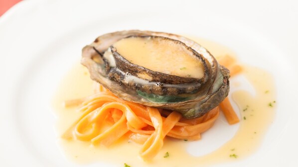 Lautasella on osteri, pastaa ja kastiketta.
