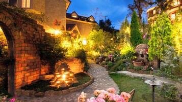 A garden with a brick archway, a pathway, and flowering plants.