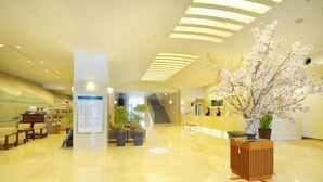 A spacious lobby with a reception desk, seating area, and a staircase leading to upper floors. - New Royal Hotel Shimanto (Shimanto)