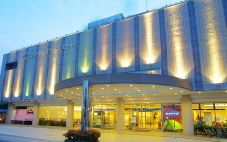 A modern hotel with a curved entrance, large glass windows, and a prominent sign.