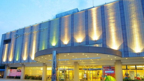 A modern hotel with a curved entrance, large glass windows, and a prominent sign. - New Royal Hotel Shimanto (Shimanto)