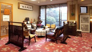A traditional Japanese-style room with tatami flooring, a low table, and a sofa.