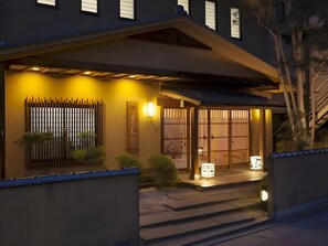 A traditional Japanese house with a wooden gate, a small garden, and a staircase leading to the entrance. - Shinshu Shimosuwa Onsen Gingetsu (Suwa)