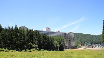 Situated in a lush green area, this multi-story building offers a serene escape amidst dense trees.
