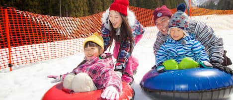 A group of people on snow tubes at a ski resort.