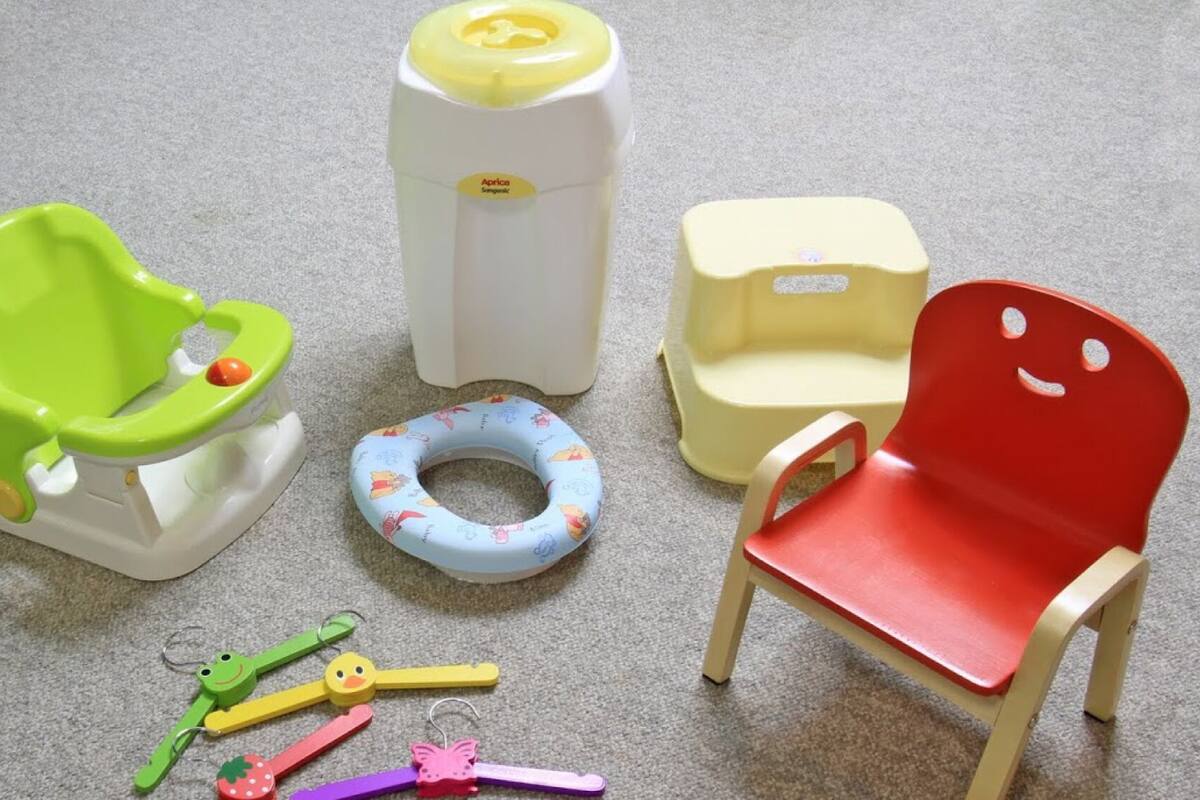 A child's potty, a toilet seat, a chair, and a toilet paper holder.