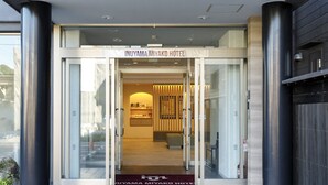 Der Eingang zum Inuyama Miyako Hotel mit modernem Design, mit einer Glastür und einem Schild über dem Eingang.