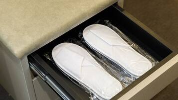 Een lade met daarin twee witte schoenen, verpakt in plastic.