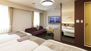 Ein Hotelzimmer mit zwei Betten, einer Schlafcouch, einem Fernseher und einem Spiegel.