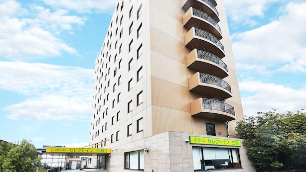 Ett högt hotell med flera balkonger, en huvudentré och en skylt som visar vilka tjänster hotellet erbjuder.