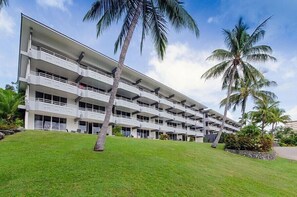 Un hôtel à plusieurs étages, doté de balcons et d’une pelouse verdoyante.