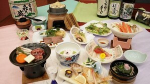 A variety of Japanese dishes arranged on a table, including a hot pot, sashimi, and a bowl of soup. - Togurakamiyamadaonsen Shunjyuan Kikusui Ryokan (Chikuma)