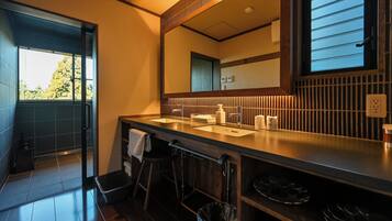 A modern bathroom with a large mirror, two sinks, and a window.