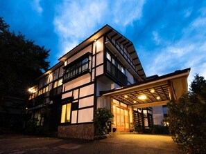 A two-story building with a traditional architectural style, featuring a balcony on the upper floor and a covered entrance. - Otowaya Ryokan (Yuzawa)