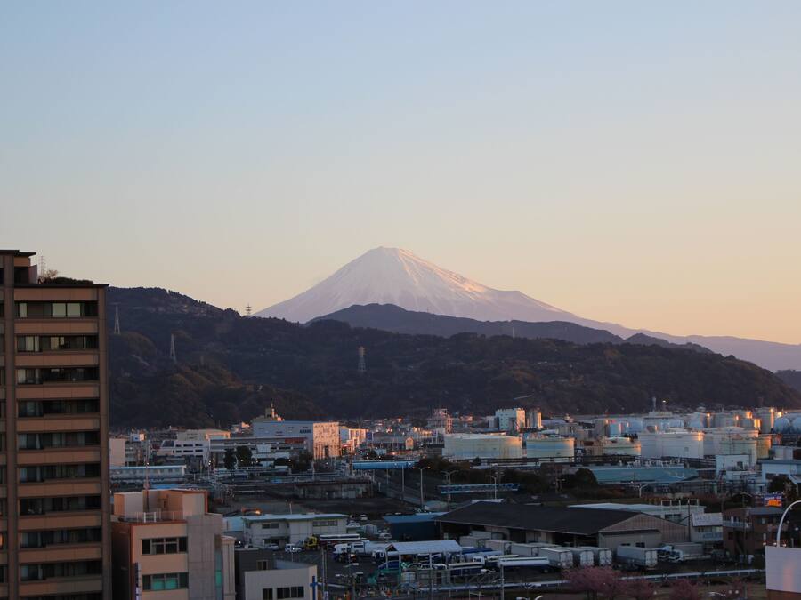A cityscape with a prominent mountain in the background.