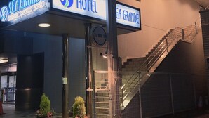 Entrada d'hotel amb un rètol que diu "SEA GRANDE HOTEL" i una escala que condueix a un nivell superior.
