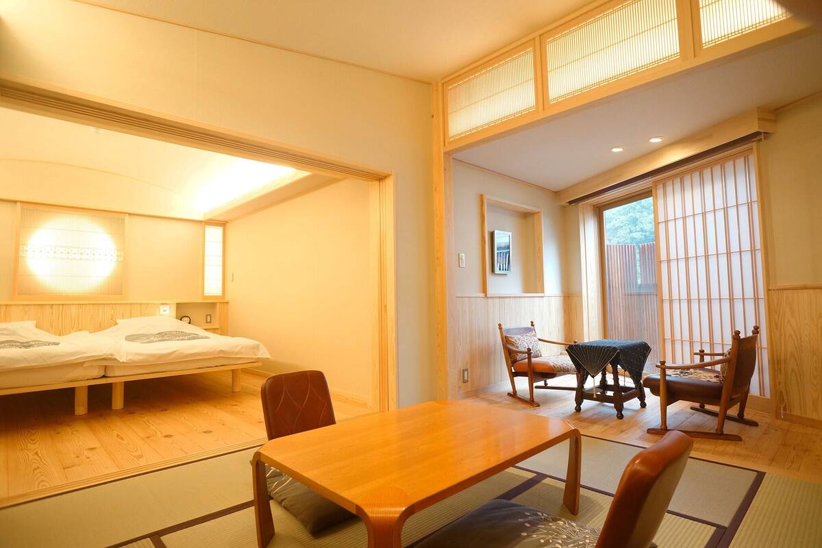 Quarto com cama, móveis de madeira, uma mesa e uma porta deslizante.