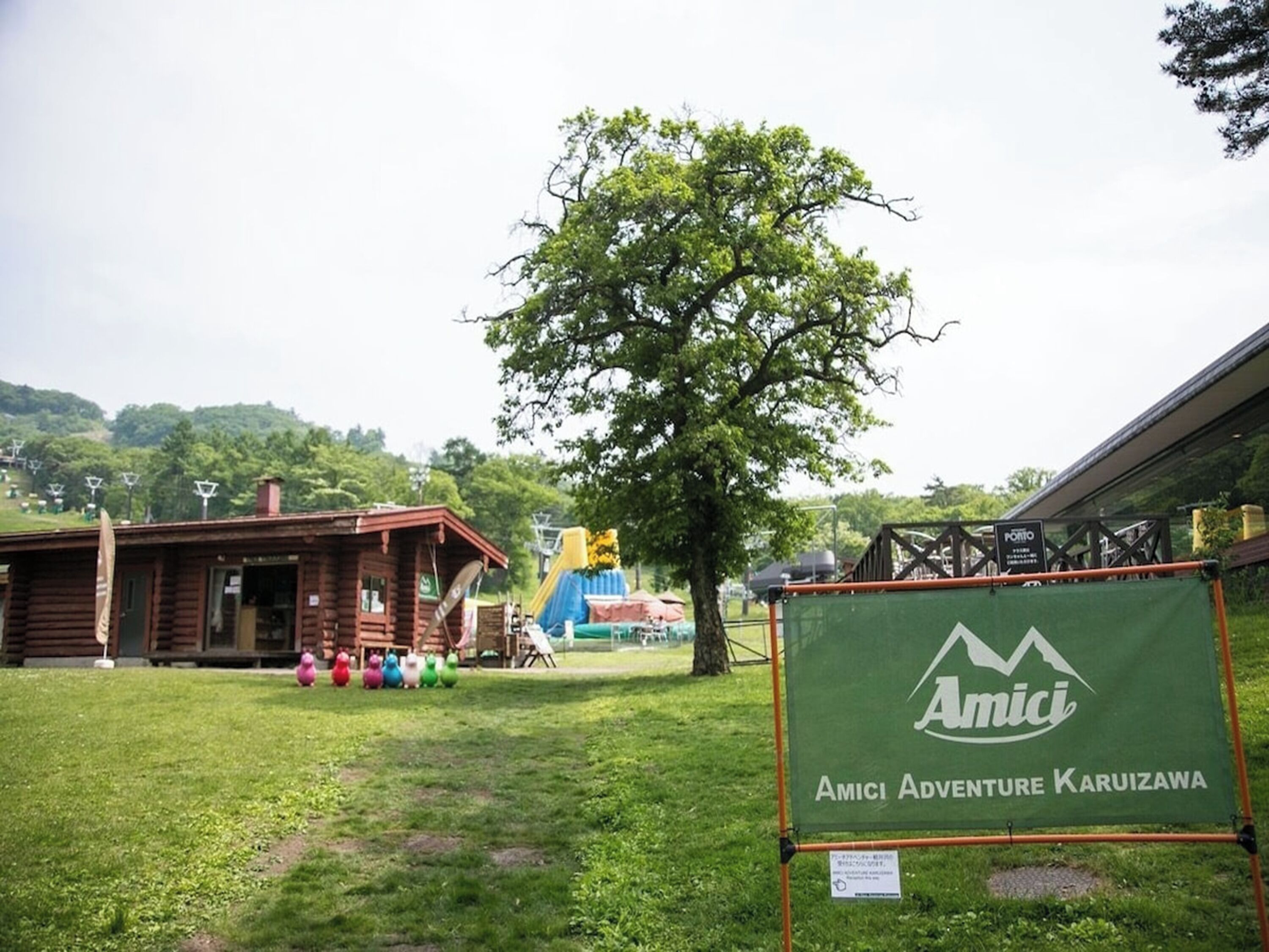 Eine Holzhütte mit Rasenfläche und einem Spielplatz im Hintergrund.