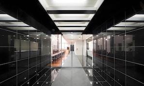 A modern interior with a reflective floor, glass partitions, and a central corridor leading to a seating area. - Access Inn Kariya (Kariya)