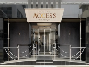 Entrada do Hotel Access, com design moderno, apresentando uma placa grande acima da entrada e uma porta de vidro.