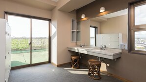A modern bathroom with a large window, two sinks, a mirror, and a view of a green landscape. - Business Hotel Koyo (Aichi)