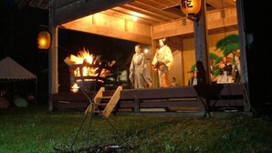 A traditional Japanese building with a wooden exterior and a large open entrance. Inside, there is a fire pit and a statue of a historical figure. - Sado Heights Hotel Aoki (Sado)