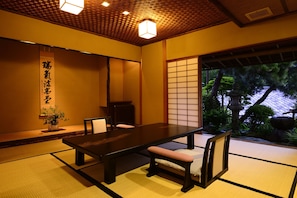 Ein traditioneller japanischer Raum mit Tatami-Böden, einem niedrigen Tisch und Schiebetüren.
